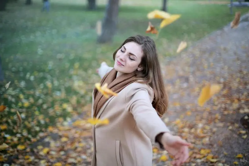 Femme souriante en extérieur représentant les bienfaits d'une séance