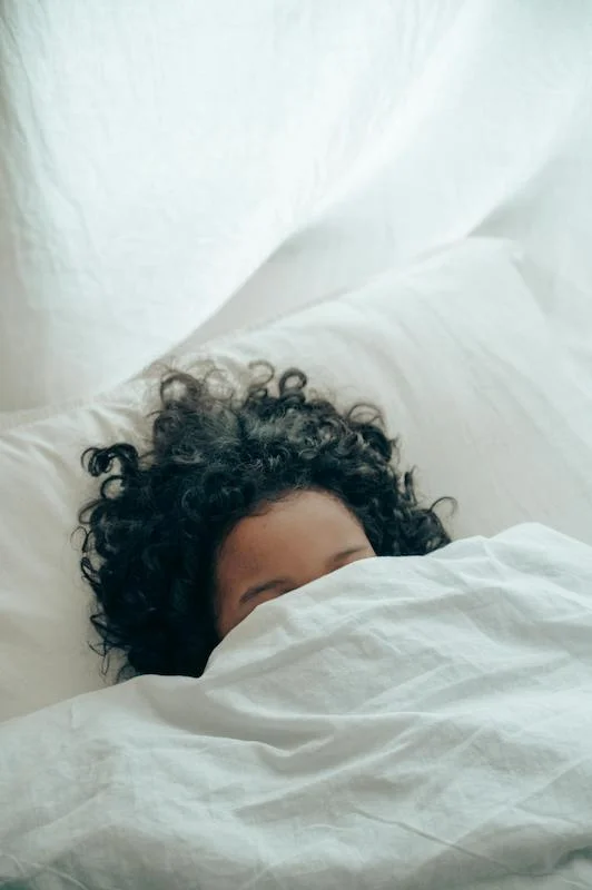 Femme sous sa couette représentant les effets secondaires de la réflexologie plantaire